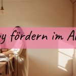 Baby fördern: Warum Tragen die beste Förderung im Alltag ist 2 Mama trägt ihr Baby im Tragetuch und erledigt entspannt Wäsche in der Küche